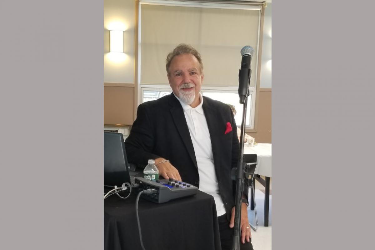 Man in Black and White Suit by Microphone and Audio Equipment