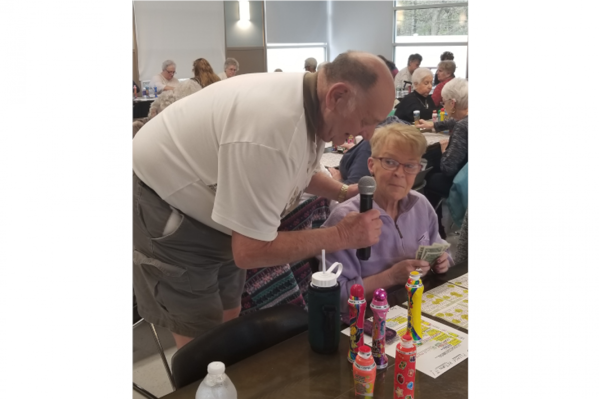 Bingo Announcer Talking with Attendee