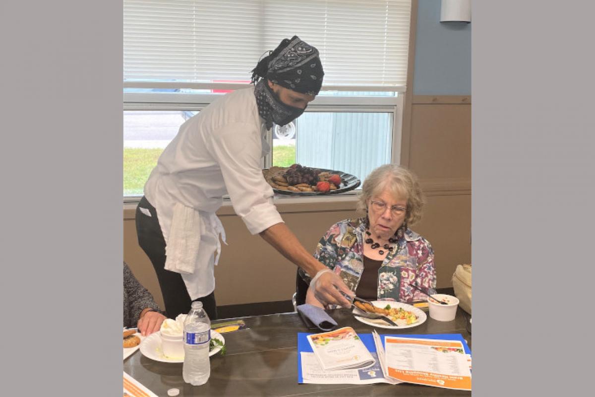 Person Serving Food to Attendee