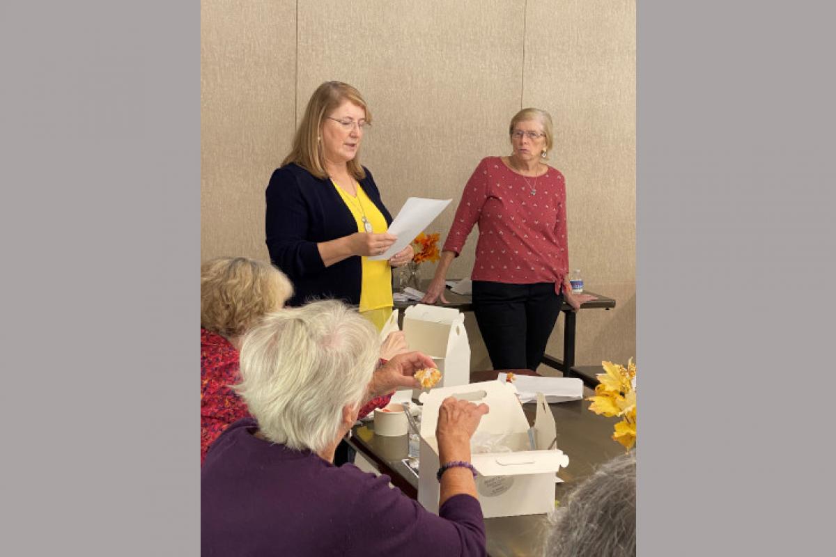 Woman Standing Up Reading from Sheet of Paper