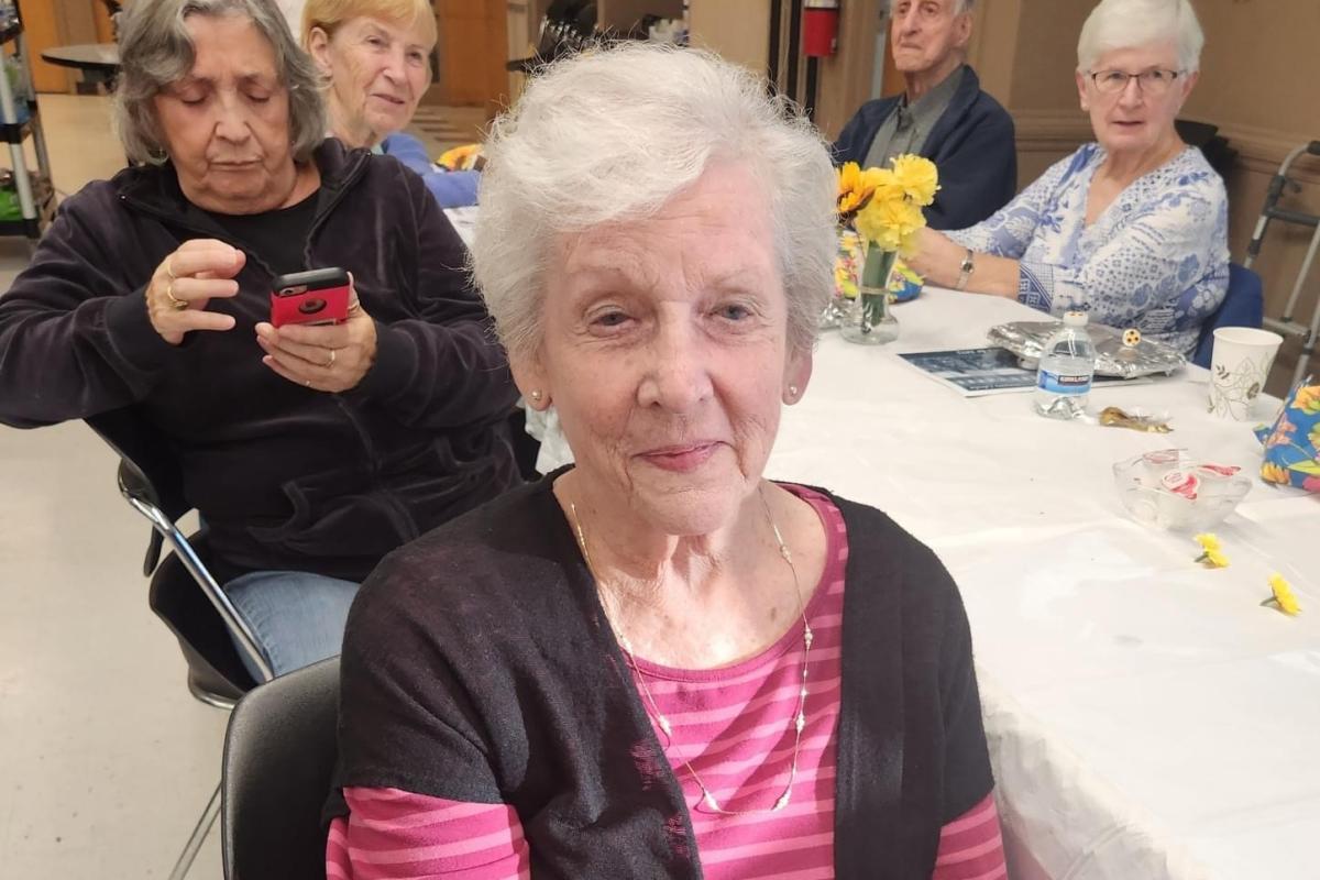Woman Seated at Table with Other Attendees