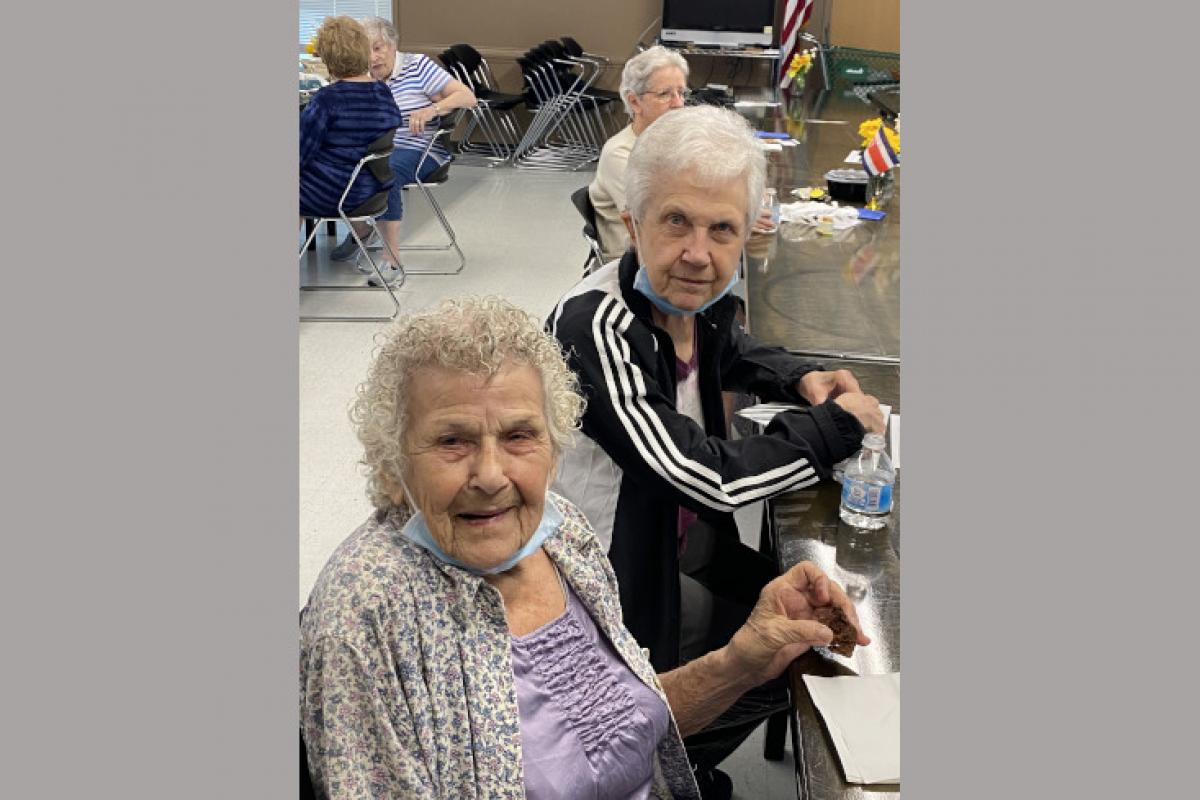 Women Seated at Table Turned Toward the Camera