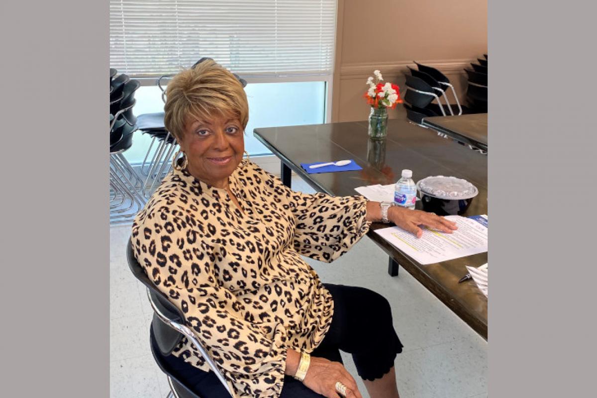 Woman Seated at Table Smiling