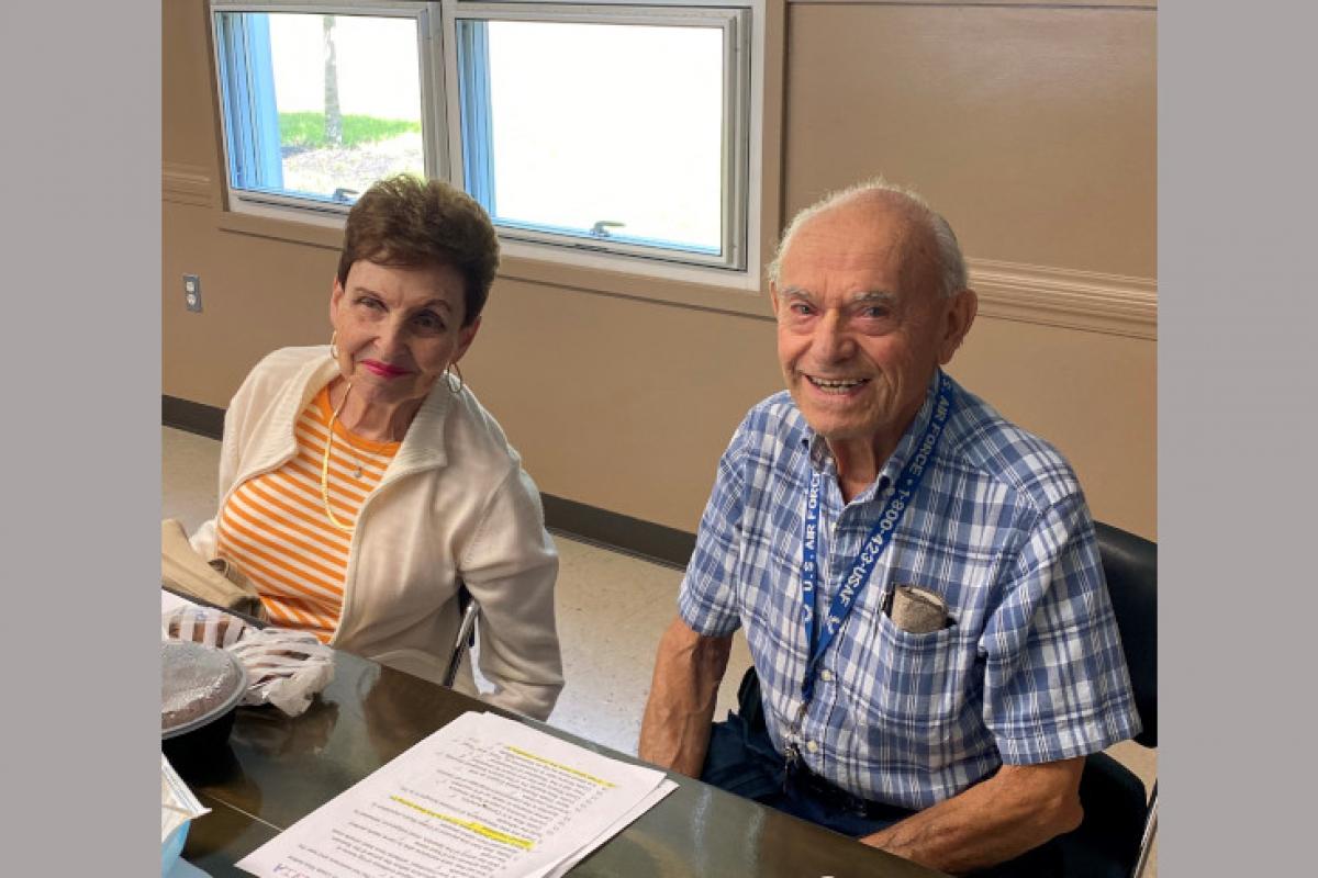 Two People Seated at Table Smiling
