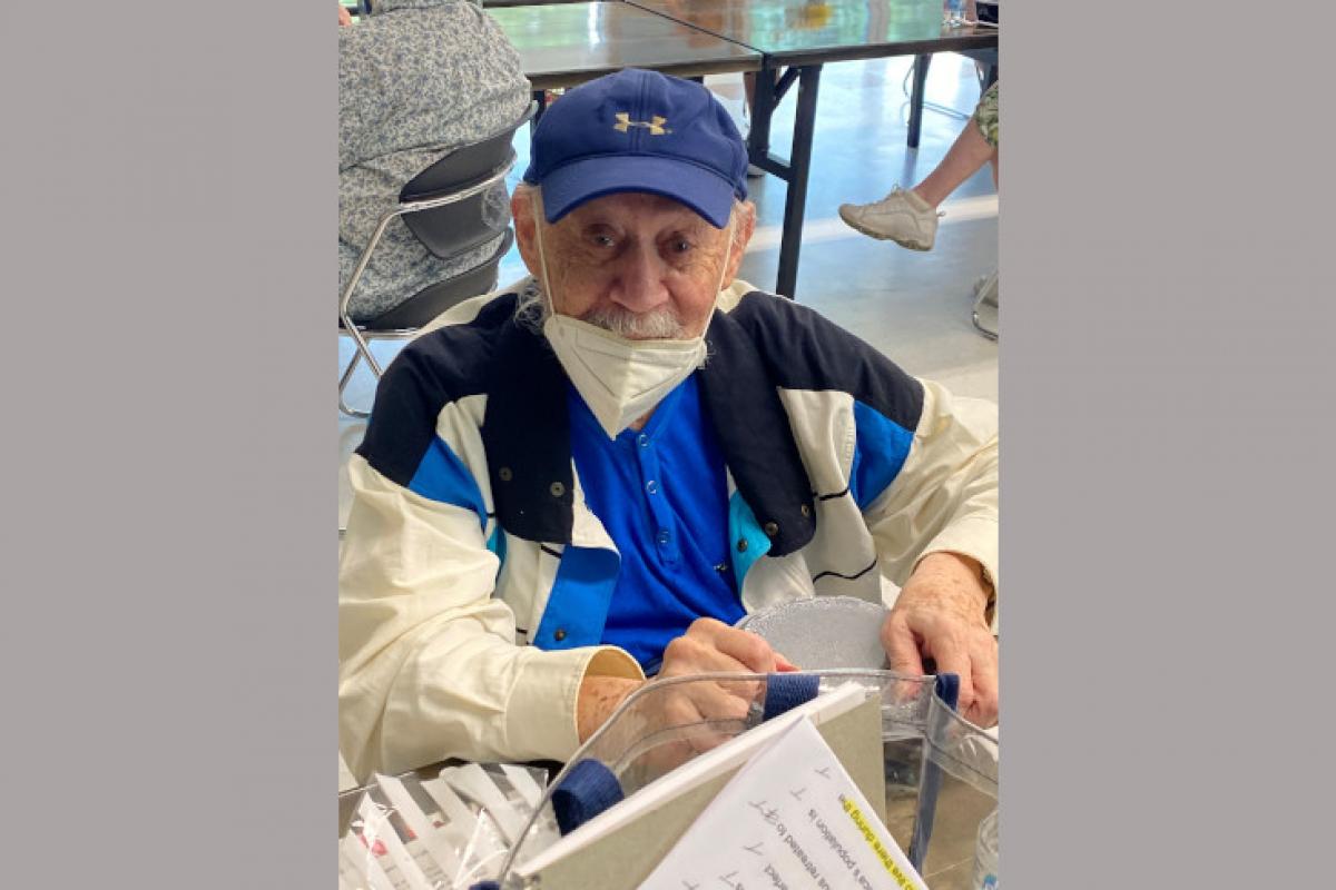 Man Seated with Food and Papers