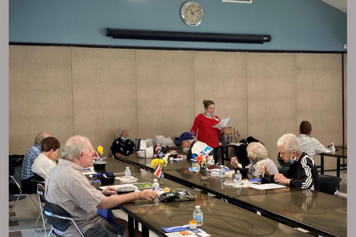 People Eating and Listening to Staff Member