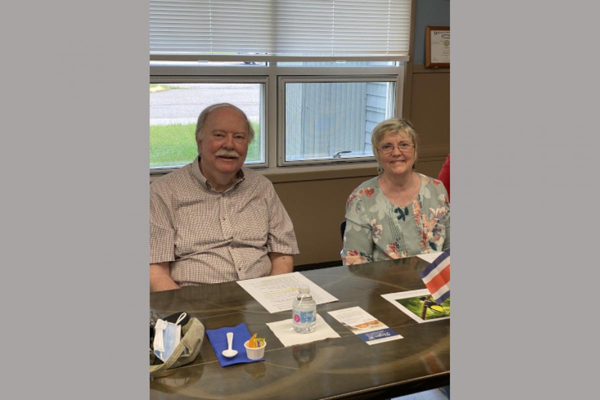 People Seated at Table with Snacks and Papers