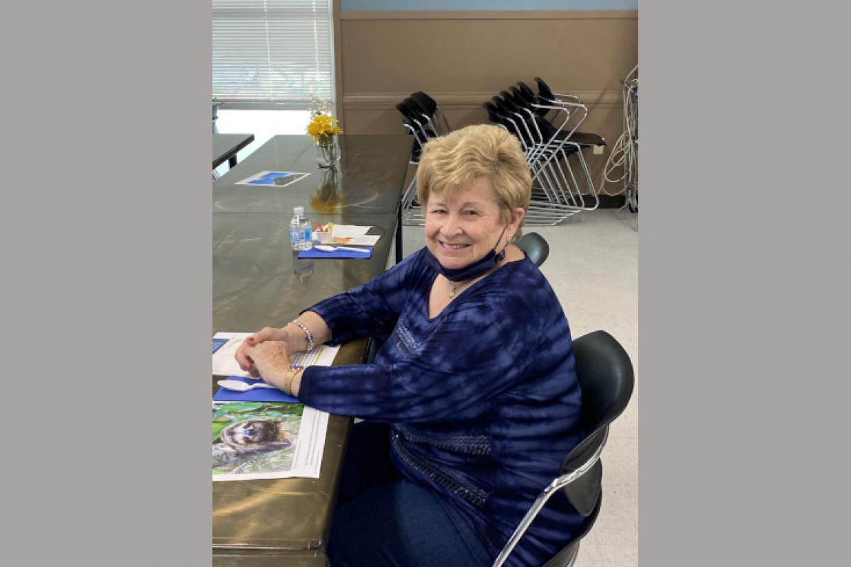 Woman Seated at Table with Program Materials